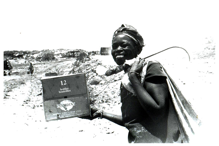 Butin - Ndei Diagne, les bras chargés du butin de la matinée. Selon sa chance et sa moisson du jour, un récupérateur peut gagner jusqu'à 5000 francs CFA (9 euros) par jour.