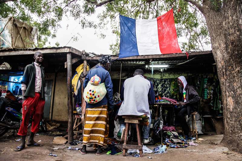 Dans le marché principal de la ville centrale de Mopti, de nombreux drapeux français décorent aussi les étals. “Maintenant qu’ils ont repris Tombouctou, dit Abdoulaye Cissé, un tailleur (à droite), tout va rentrer dans l’ordre. On va enfin pouvoir dormir tranquille.”